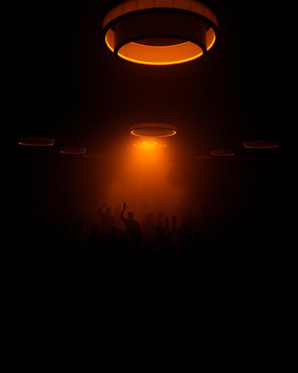 Crowd under glowing amber halos